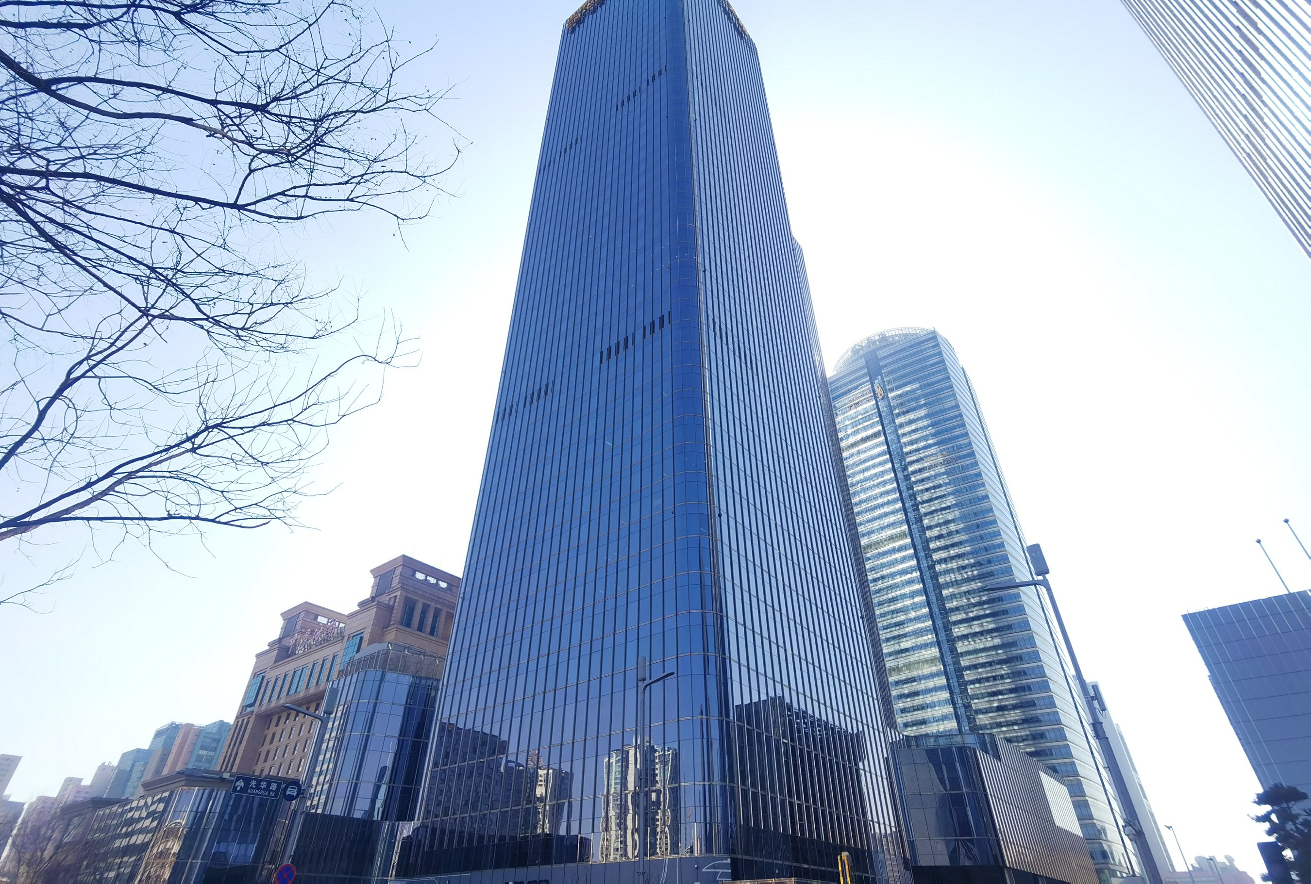 北京正大中心双塔近景，玻璃幕墙与蓝天白云